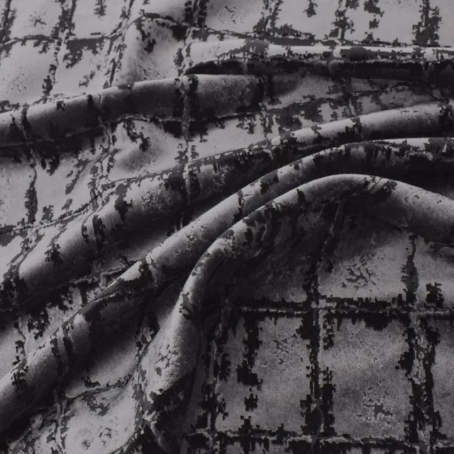 Black and charcoal plush fabric with a distressed grid motif draped in sculptural folds
