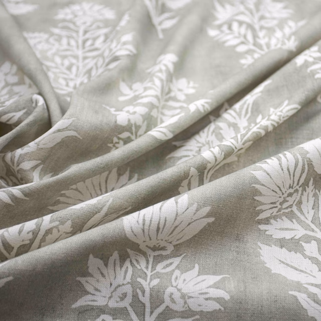 Sage-grey fabric with chalk-white botanical flowers and leafy stems in soft folds