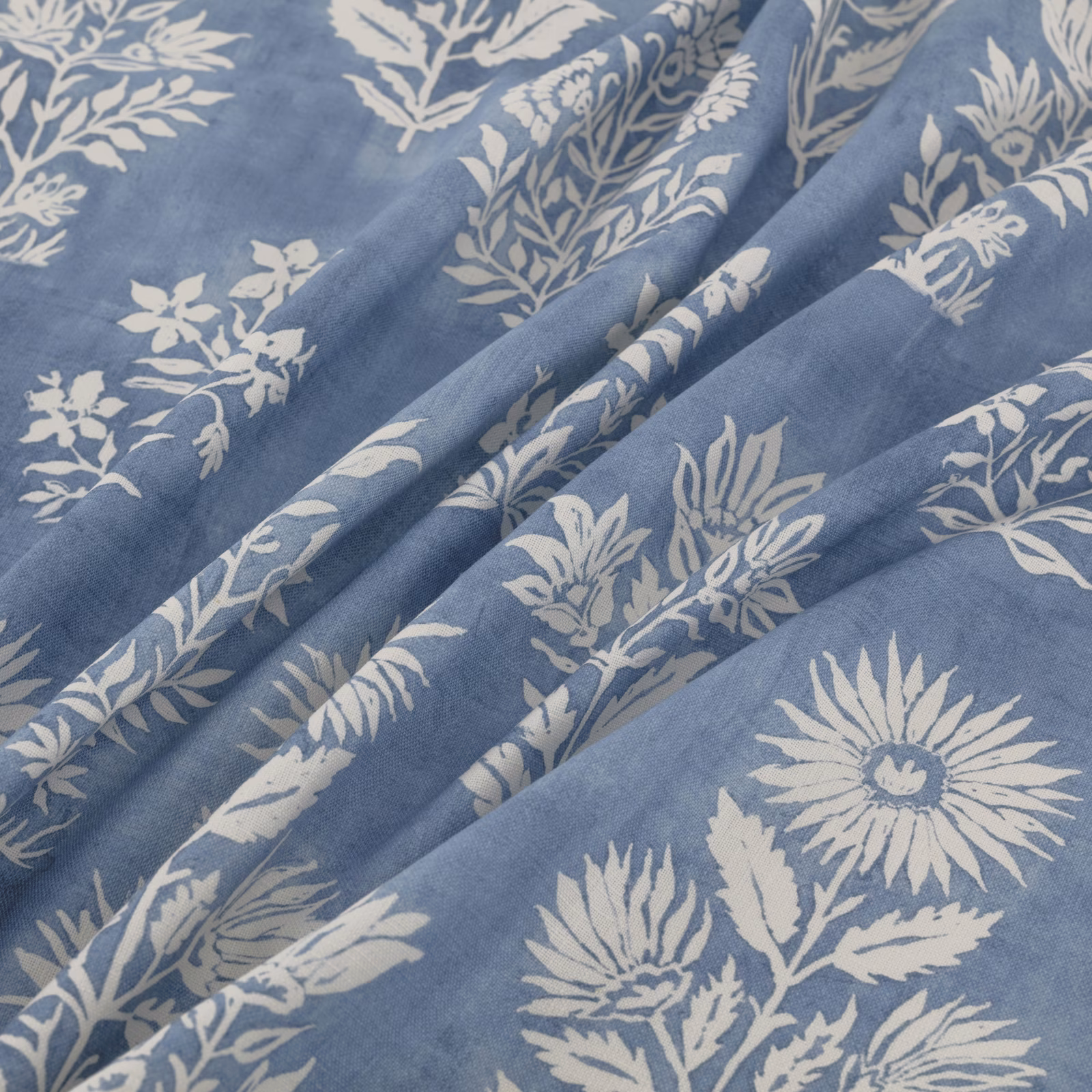 Dusty blue fabric with ivory daisies, leafy sprigs and softly folded texture