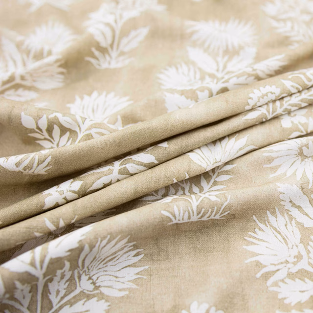 Warm jute-beige fabric with ivory botanical sprays and a softly textured ground