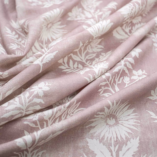 Dusty blush-pink floral fabric with ivory flowers and leafy stems in soft folds