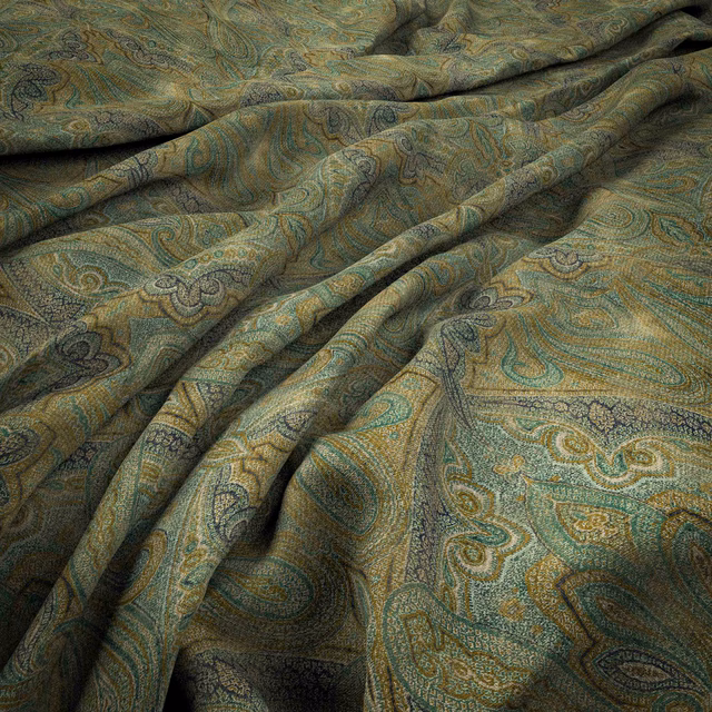 Muted chartreuse paisley fabric with teal scrolls and softly lustrous woven texture