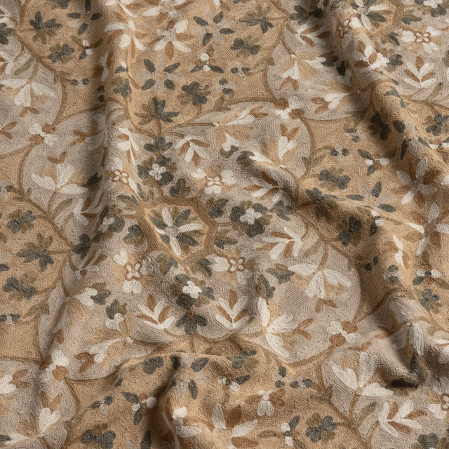 Warm taupe floral fabric with cream petals and charcoal-olive leaves in textured folds