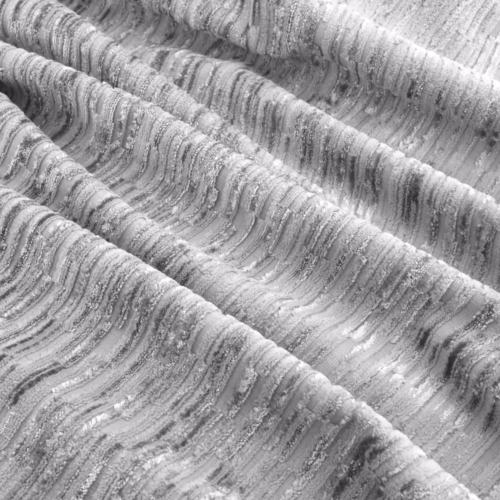 Cool silver-grey fabric with raised rippling striations and reflective charcoal shadows