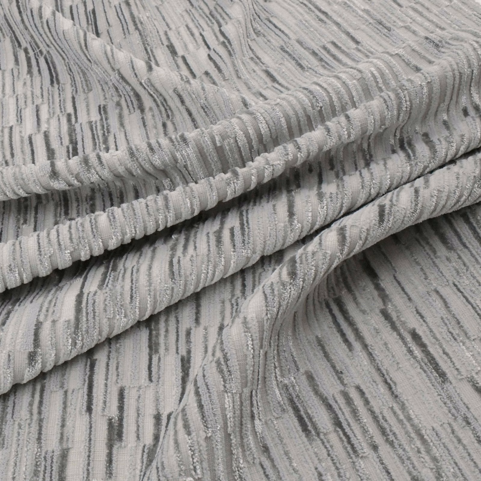 Cool basalt-grey fabric with raised ribs and irregular charcoal vertical striations