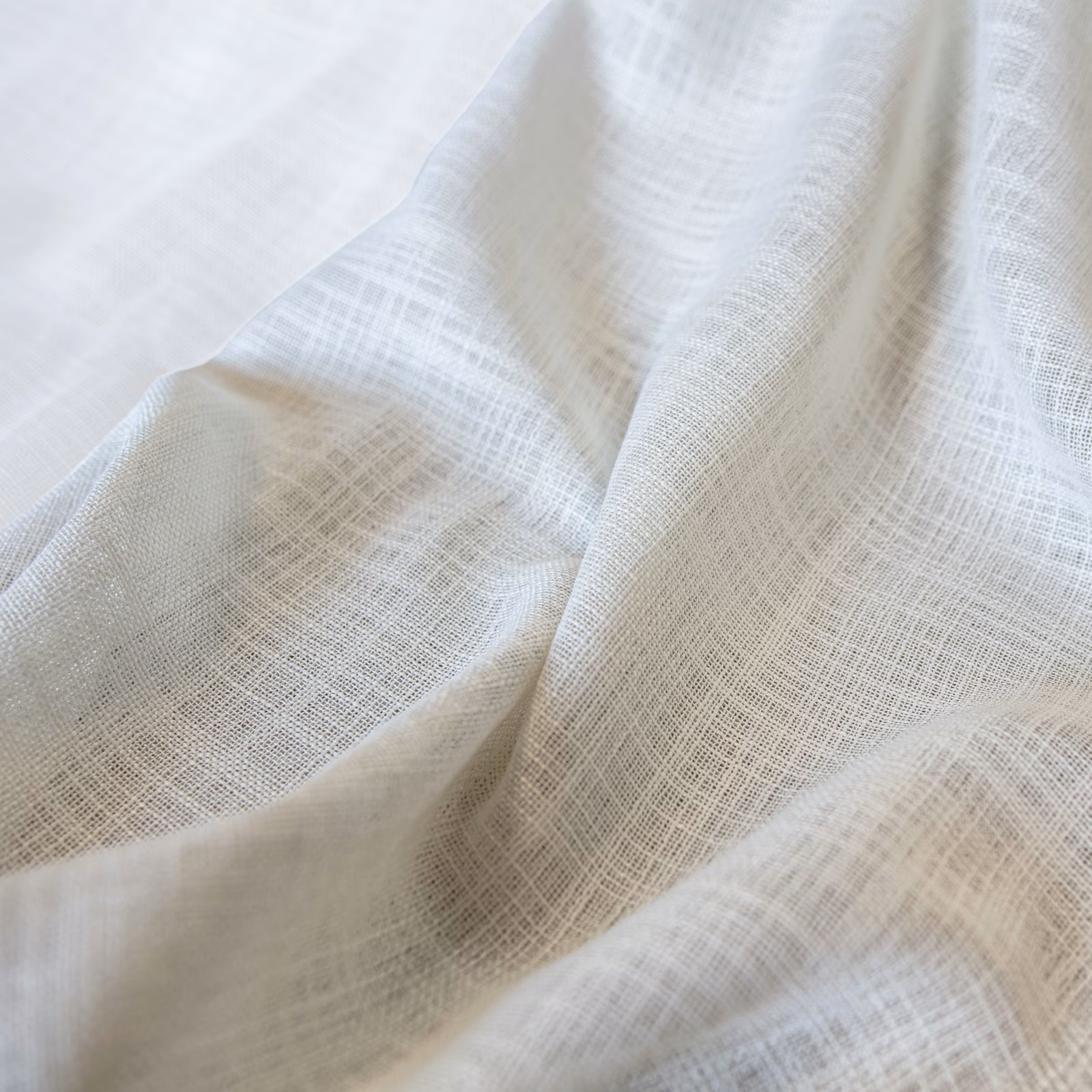 Ivory cream Santorini fabric with an open crosshatch weave in soft folds