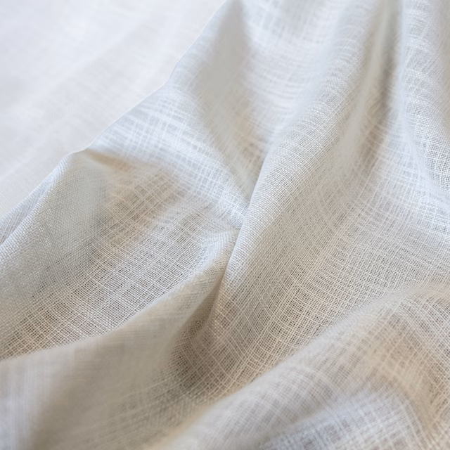 Ivory cream Santorini fabric with an open crosshatch weave in soft folds