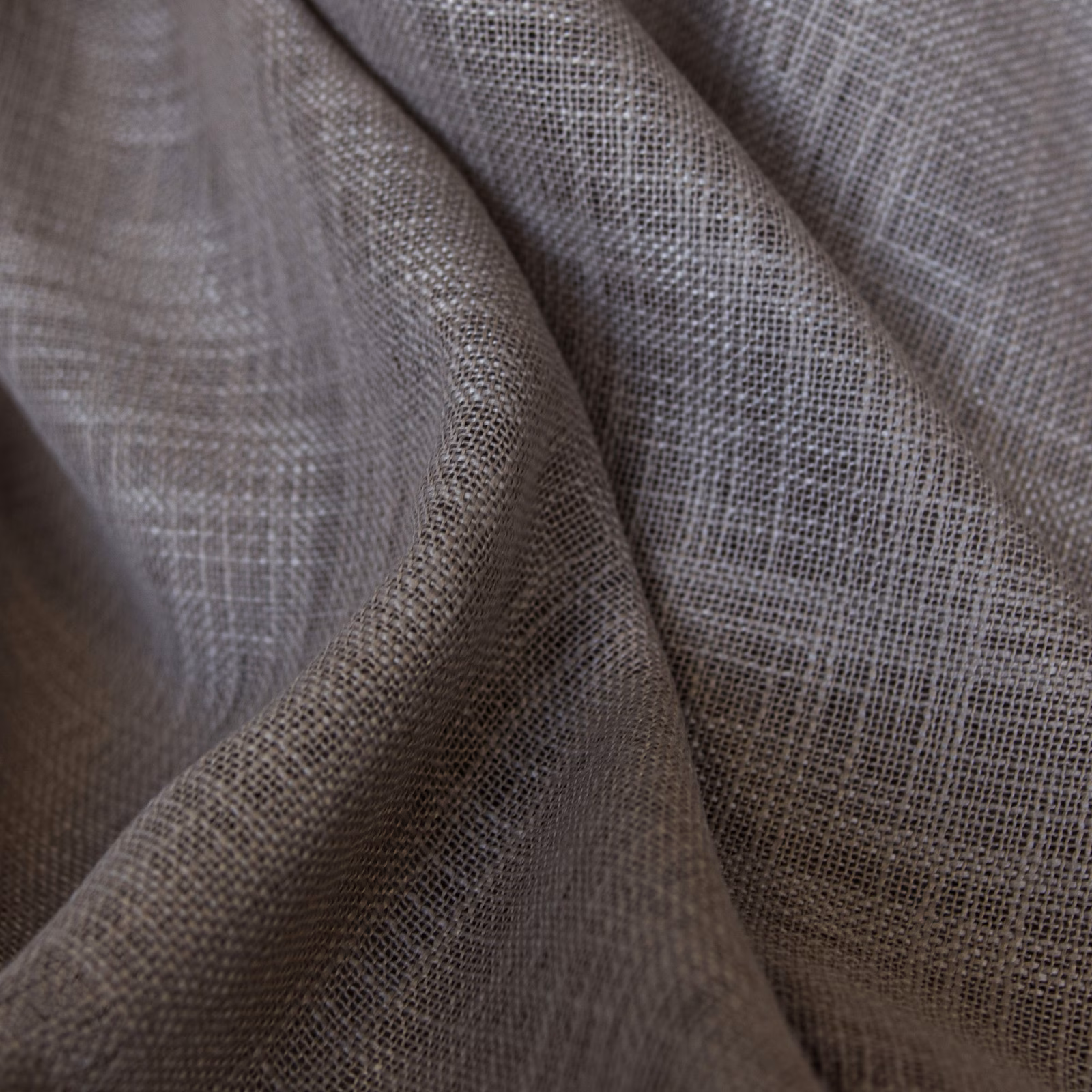 Muted taupe-grey open weave forming softly folded, semi-sheer textile surfaces