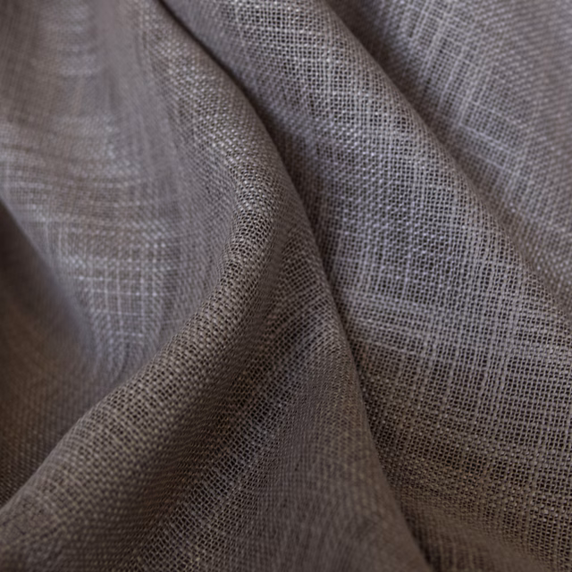 Muted taupe-grey open weave forming softly folded, semi-sheer textile surfaces