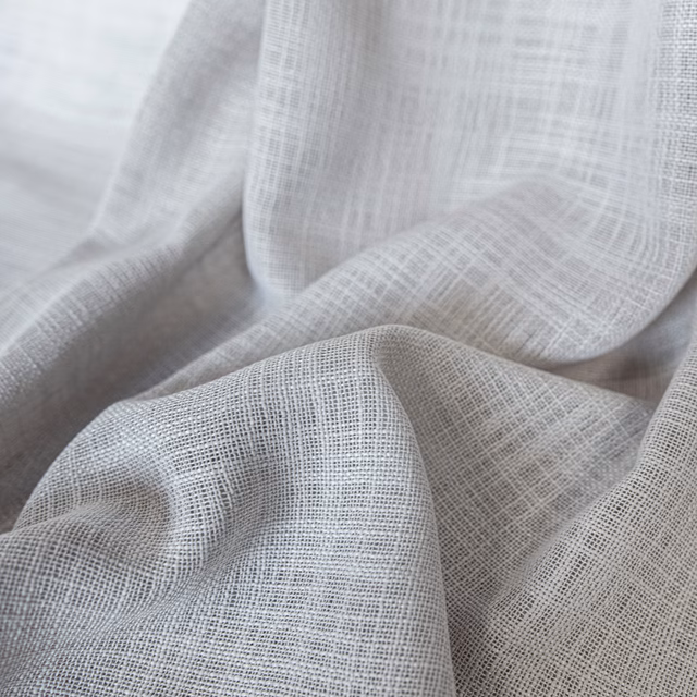 Pale natural-grey open-weave fabric gathered into softly translucent folds