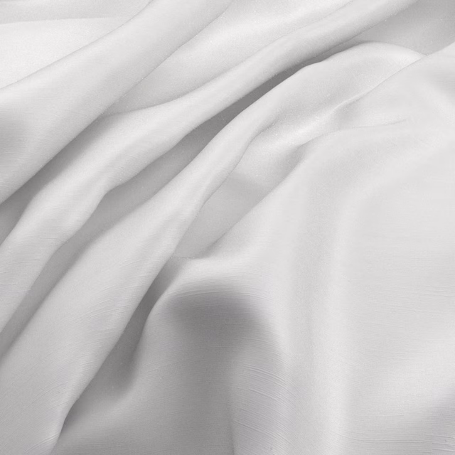 Pearl-white fabric in fluid folds, showing a fine weave and soft satin-like sheen