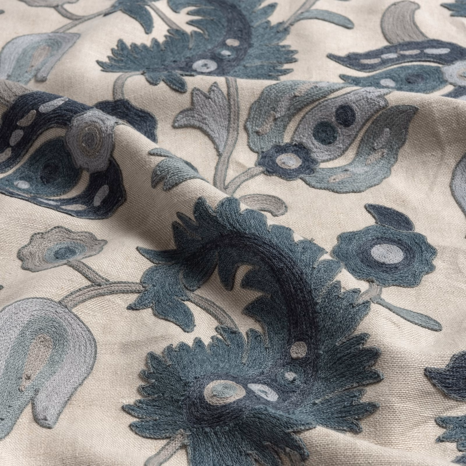 Ivory fabric with large blue-grey flowers, curling leaves and softly textured surface