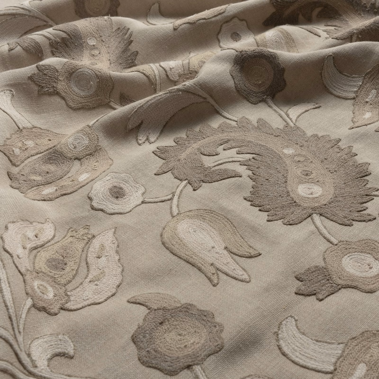 Warm parchment fabric with raised taupe flowers, curling leaves and paisley motifs