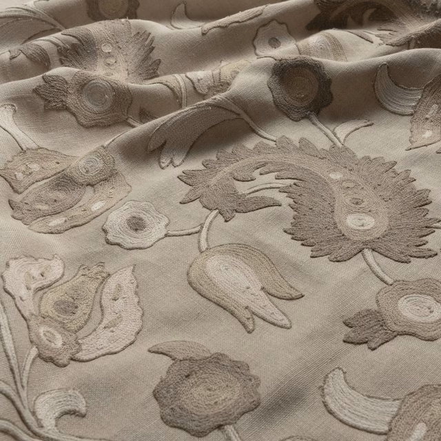 Warm parchment fabric with raised taupe flowers, curling leaves and paisley motifs