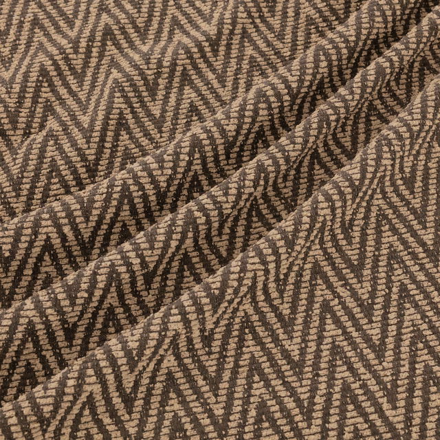 Warm taupe-brown woven textile with dark broken zigzags and raised ridged texture