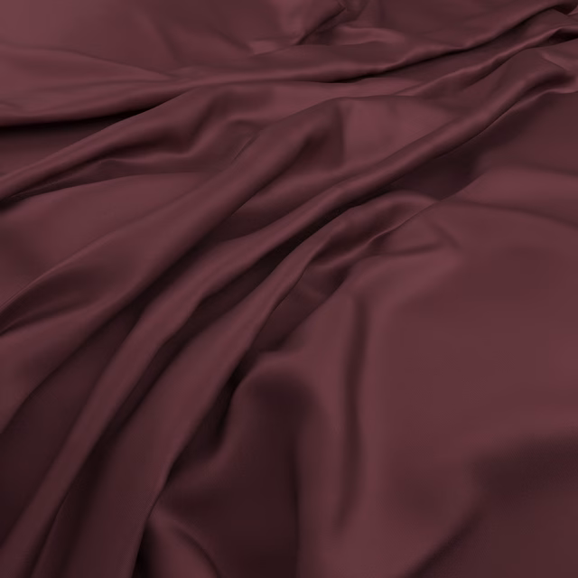 Deep bordeaux fabric gathered into fluid folds with soft plum shadows and sheen