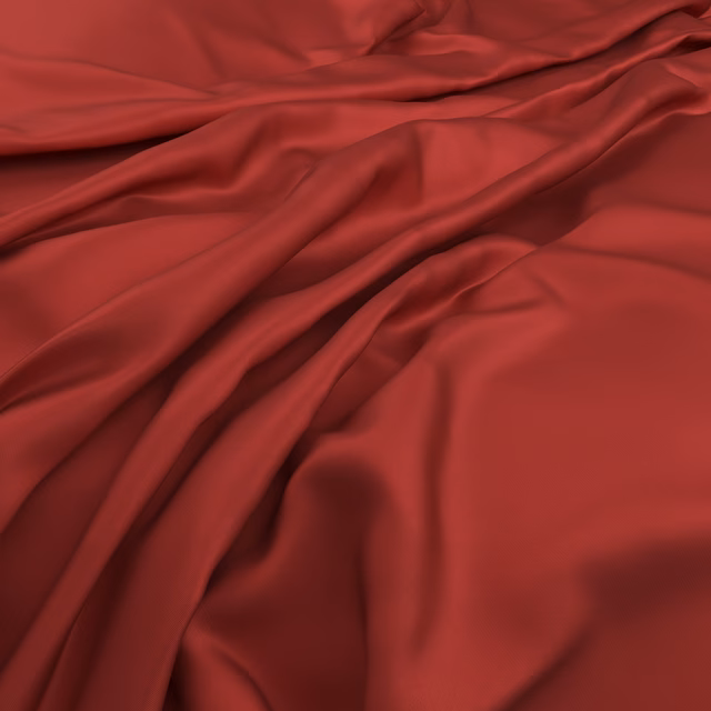 Deep crimson red fabric falling in smooth, softly lustrous flowing folds