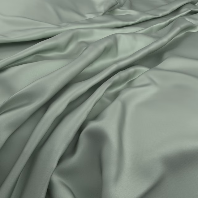 Smooth muted sea-green fabric with soft sheen falling in fluid gathered folds