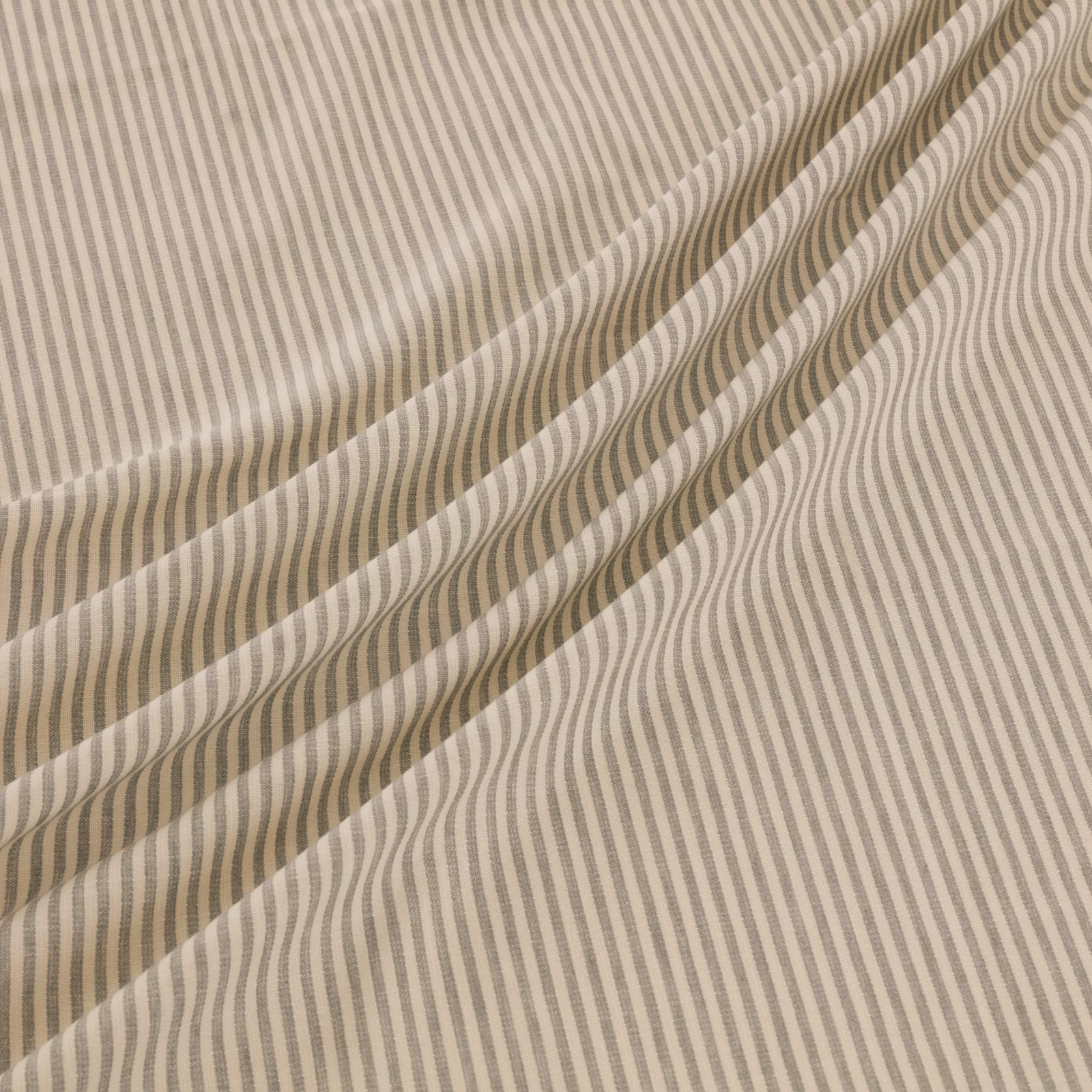 Soft taupe and ivory wavy stripe fabric draped in loose folds
