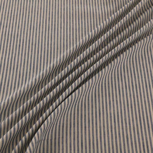 Taupe woven fabric with narrow undulating navy vertical stripes and folded texture