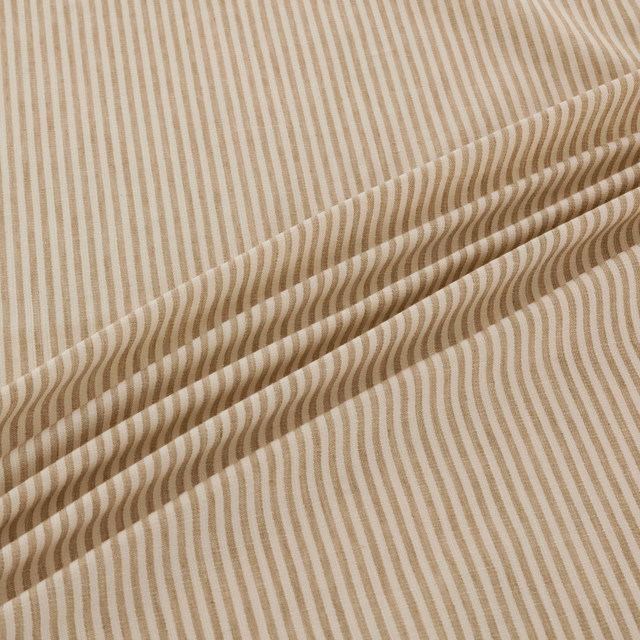 Warm papyrus-beige fabric with fine vertical stripes bending into waves across a fold