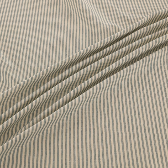 Blue-grey irregular vertical stripes on an ivory woven fabric, folded into soft diagonal layers