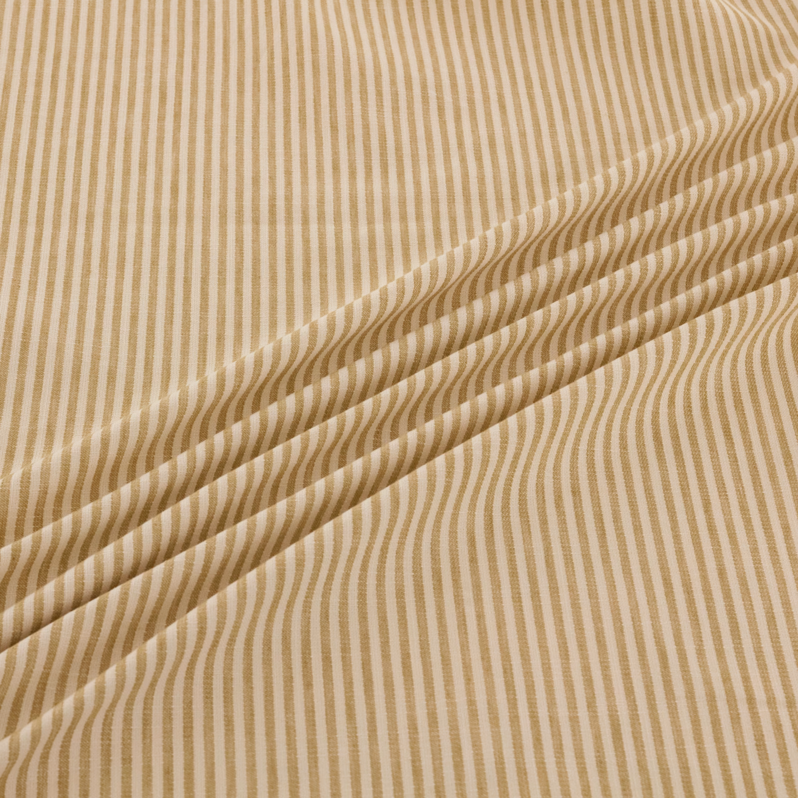 Warm sand fabric with tan undulating vertical stripes and a folded drape