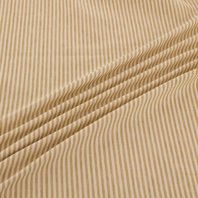 Warm sand fabric with tan undulating vertical stripes and a folded drape
