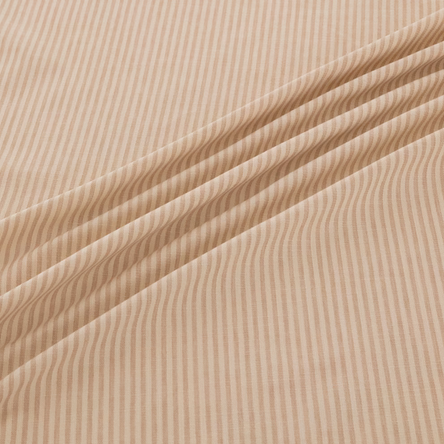 Warm shell-beige fabric with fine undulating stripes arranged in soft flowing folds