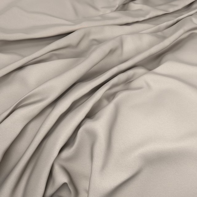 Warm buttermilk fabric gathered into smooth, softly reflective folds