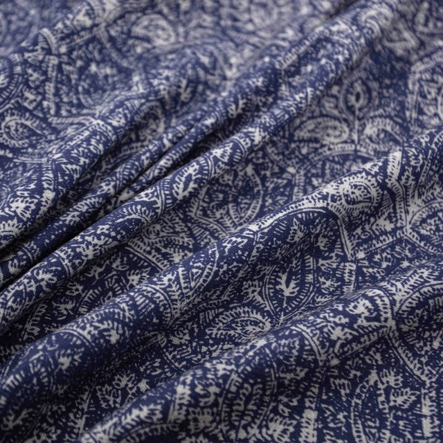 Deep indigo and ivory paisley fabric gathered into softly textured folds