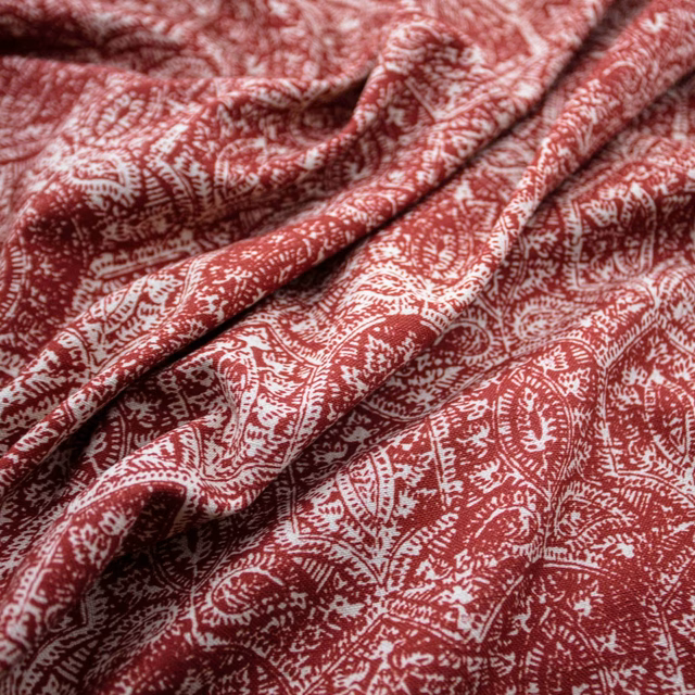 Deep berry-red Simla fabric with ivory paisley foliage motifs draped in soft folds