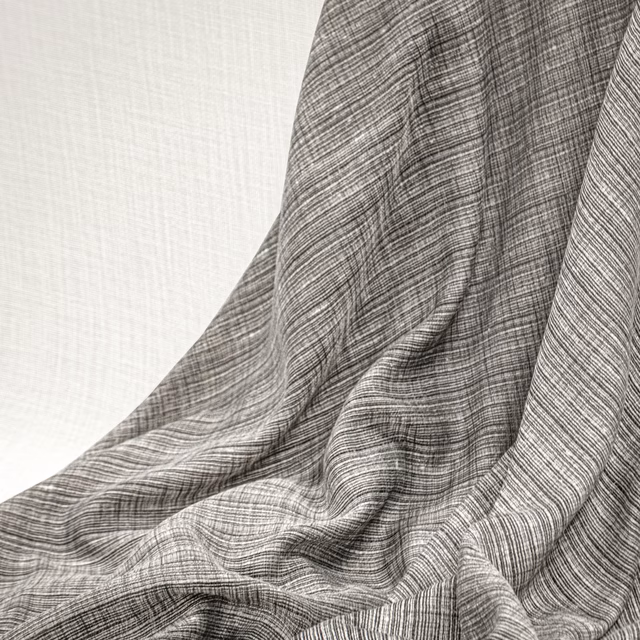 Cool silver-grey woven cloth with fine linear texture and softly gathered folds