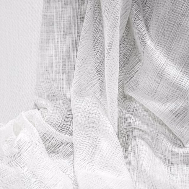Soft white sheer fabric with fine crosshatch weave gathered into flowing folds