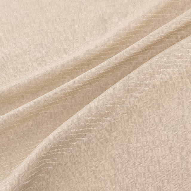 Pale champagne-gold fabric with fine rippled weave draped in soft diagonal folds