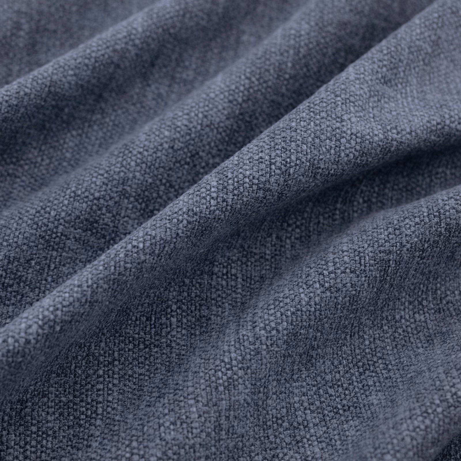 Close-up of dark indigo-blue woven cloth with nubby texture in soft folds