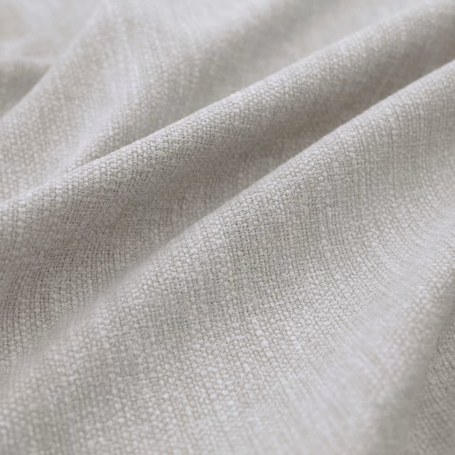 Pale mist-grey woven textile gathered into soft folds with a fine tactile grid