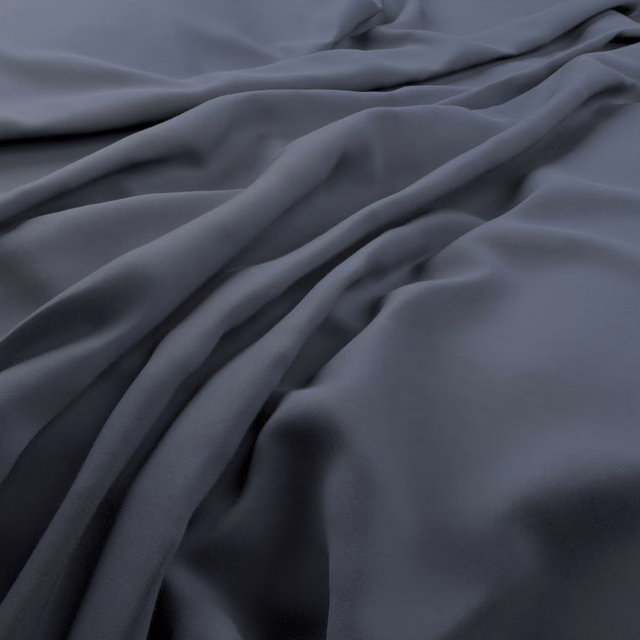 Deep blue-grey Solaire fabric falling in broad, softly reflective folds