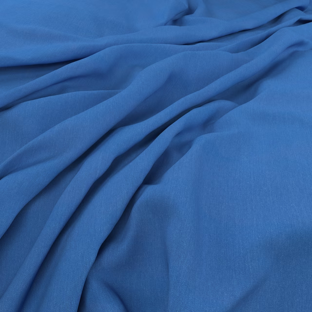 Cool Atlantic-blue cloth gathered into soft, fluid folds with a fine weave