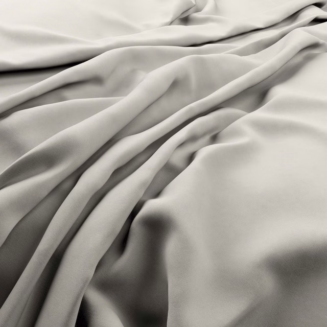 Pale beach-beige fabric in fluid folds with a gentle surface sheen