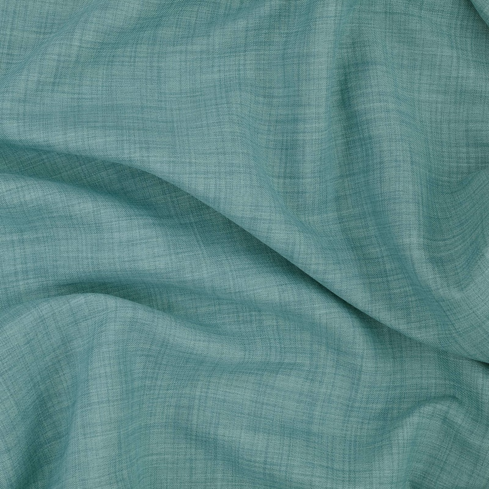Close-up of cool lagoon teal fabric with fine crosswoven texture in fluid folds