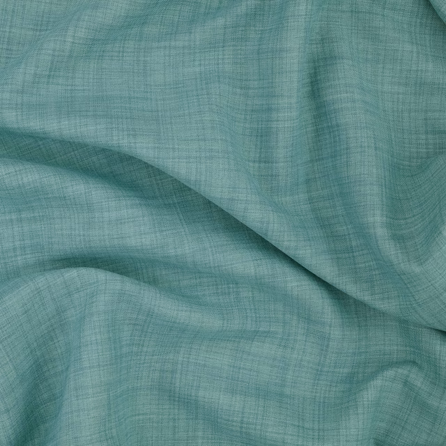 Close-up of cool lagoon teal fabric with fine crosswoven texture in fluid folds