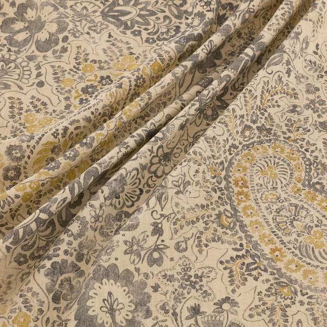 Warm beige floral-paisley fabric with charcoal, grey and ochre detailing in soft folds