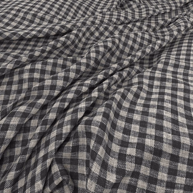Charcoal and pale grey woven check fabric gathered into softly textured folds