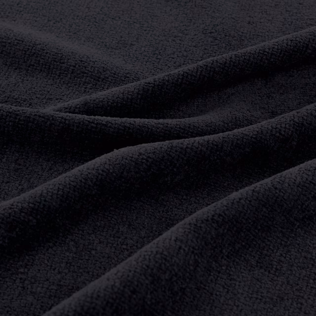 Deep jet-black fabric with a softly raised, fine-grained surface in sculptural folds