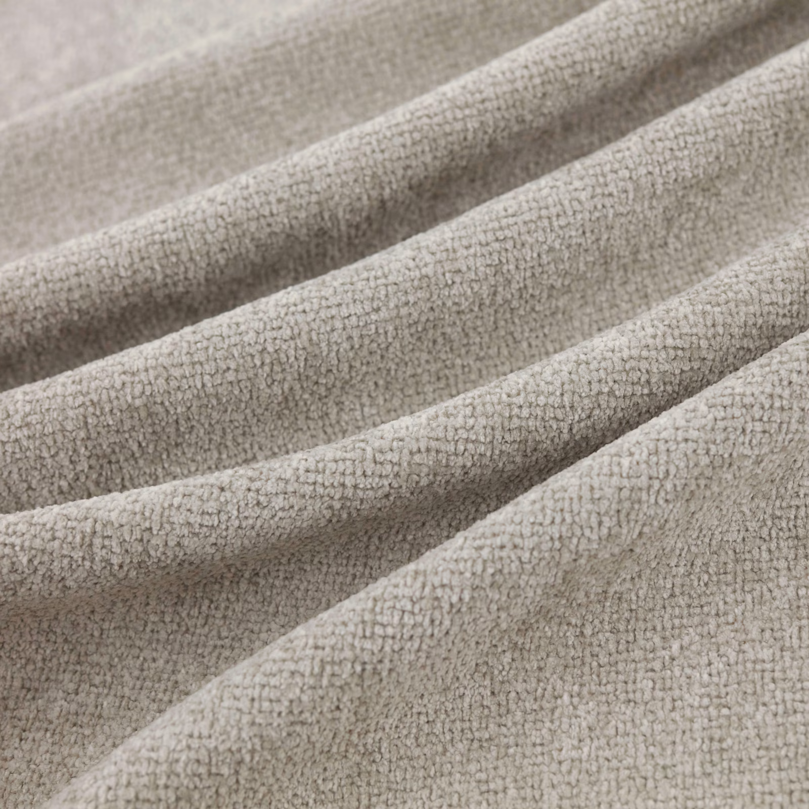 Pale silver-grey nubby fabric with a softly pebbled weave folded into broad tactile ridges