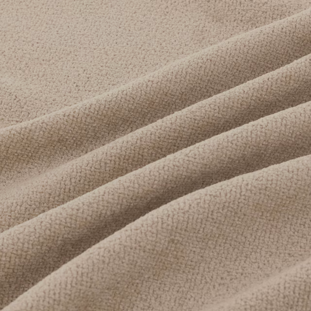 Warm oatmeal-beige folded textile showing a fine, pebbled loop texture
