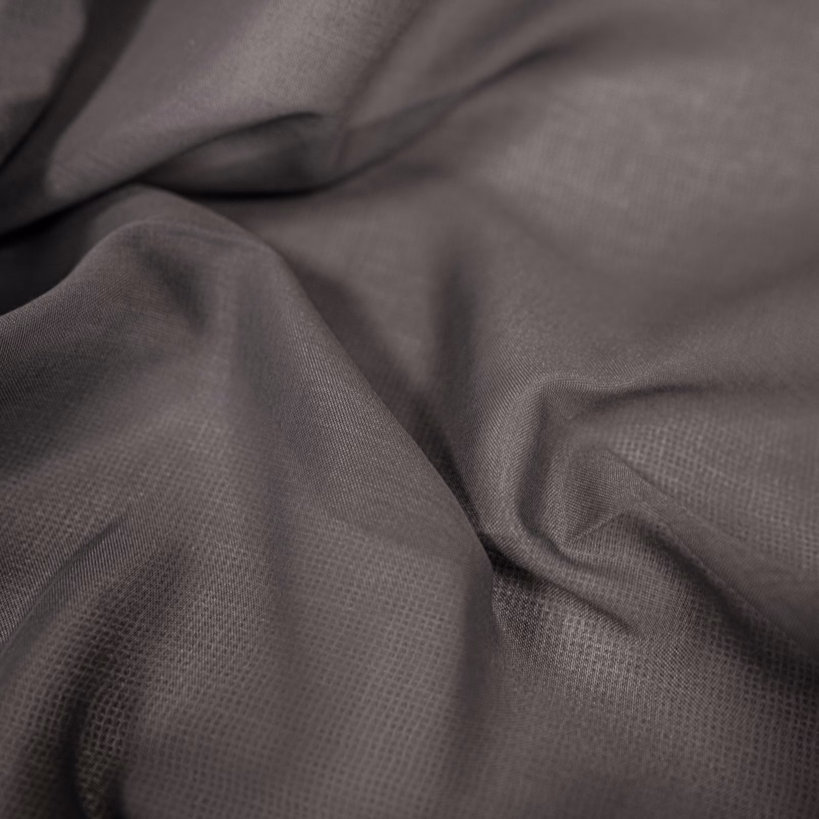 Charcoal-grey woven fabric showing fine crosshatch texture in softly gathered folds