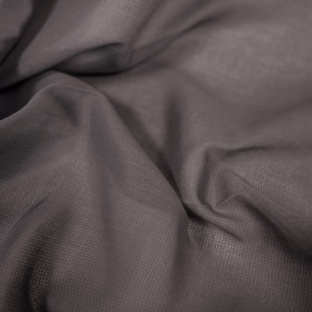 Charcoal-grey woven fabric showing fine crosshatch texture in softly gathered folds