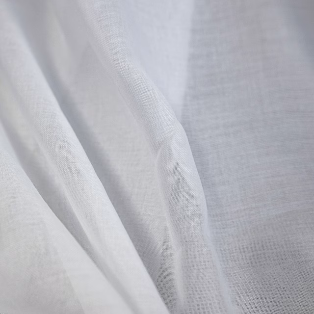 Optic white sheer fabric with open weave and softly rippled folds